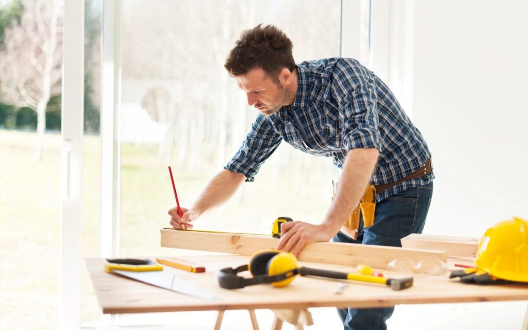 A man working on a table with tools in front of him.